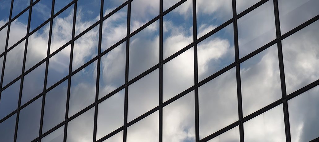 Reflection of the sky in glass windows of a large building