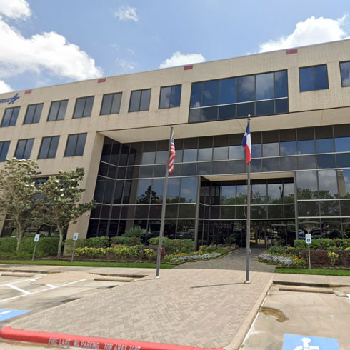 The exterior of the HORNE Houston office, with an American flag and the Texas flag blowing in the breeze.